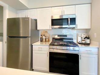 a kitchen with white cabinets and stainless steel appliances
