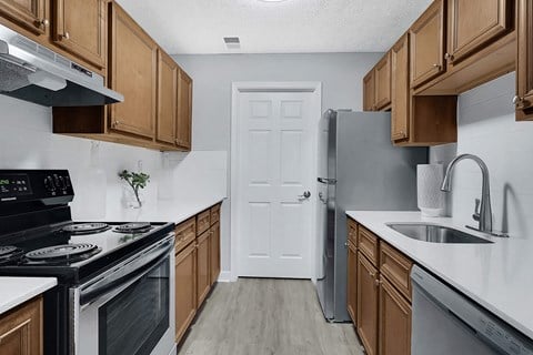 a kitchen with wooden cabinets and stainless steel appliances at Stonewater Apartments, Louisville, 40241