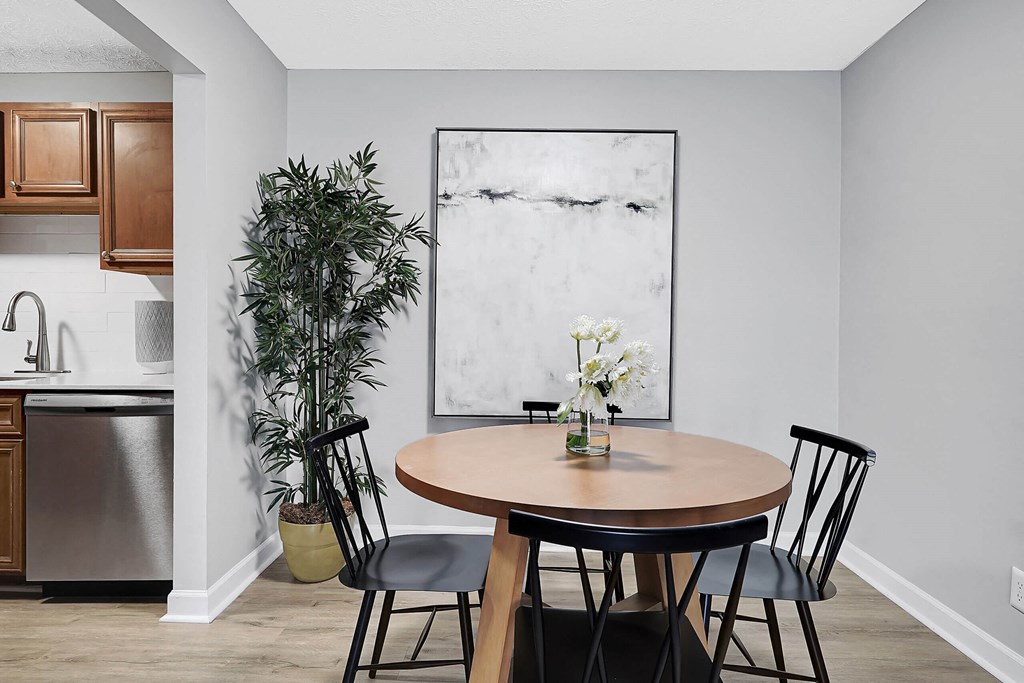 a dining area with a round table and four black chairs at Stonewater Apartments, Louisville, KY