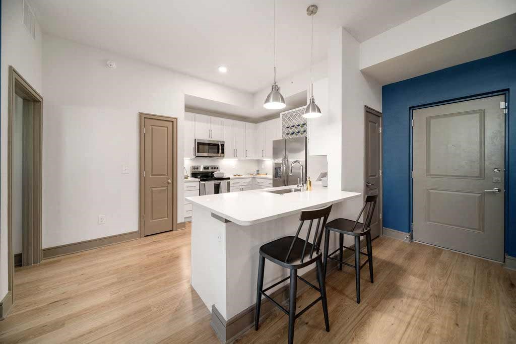 an open kitchen with a large island with three stools