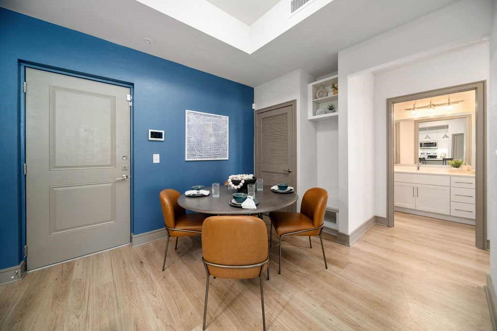 a dining room with a table and chairs and a blue wall