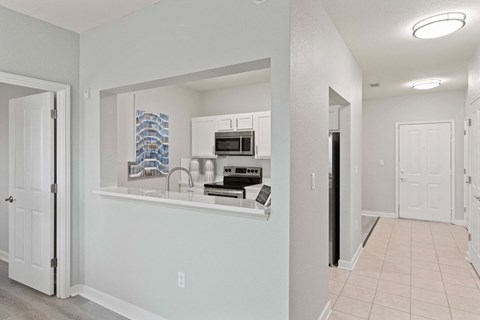 A kitchen with white cabinets and a microwave above the stove.