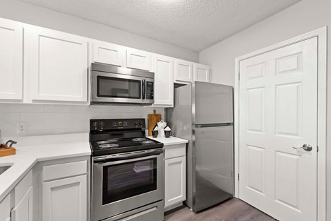 A kitchen with white cabinets and stainless steel appliances.