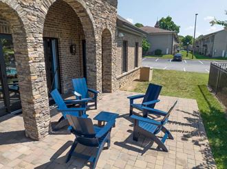 a patio with three blue adirondack chairs and a parking lot in the background at Enclave at Breckenridge, Louisville Place Kentucky - Photo Gallery 3