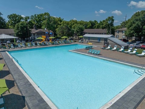 a large swimming pool with lounge chairs and umbrellas at Enclave at Breckenridge Apartments, Louisville, Kentucky