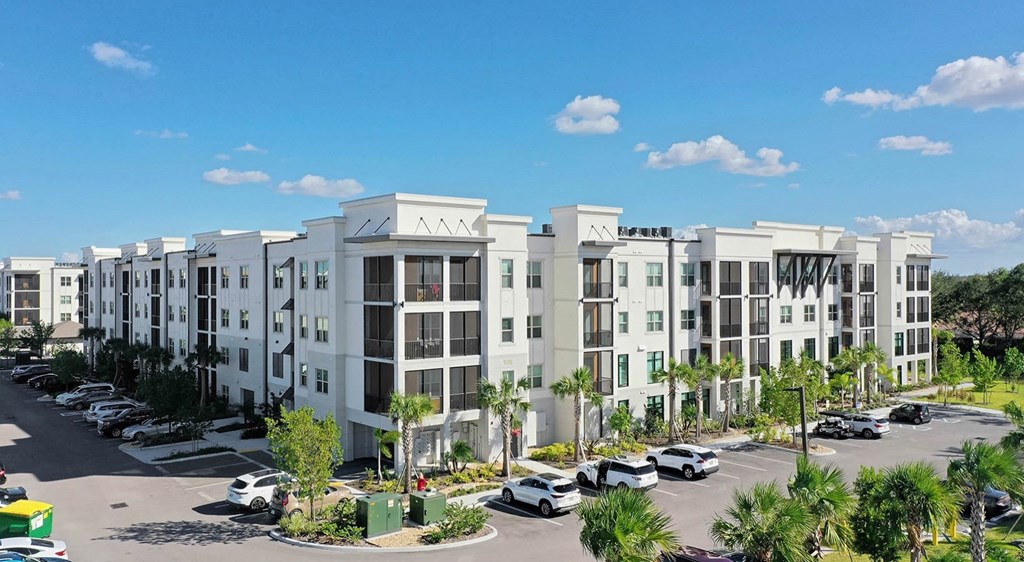 an aerial view of an apartment complex with a parking lot
