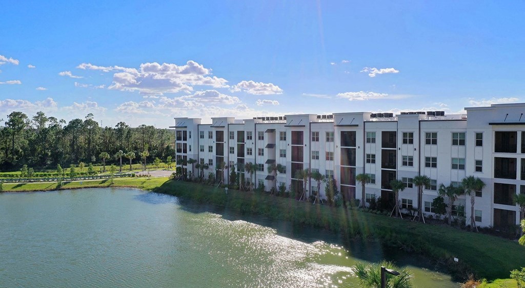an aerial view of an apartment building next to a body of water