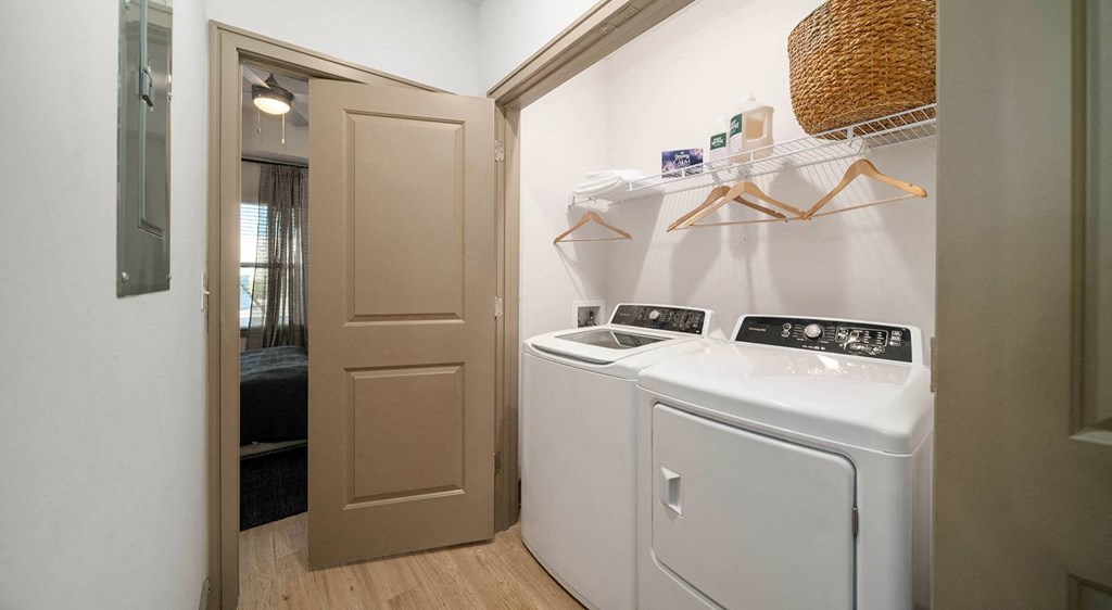 a laundry room with a washer and dryer and a door to a bathroom