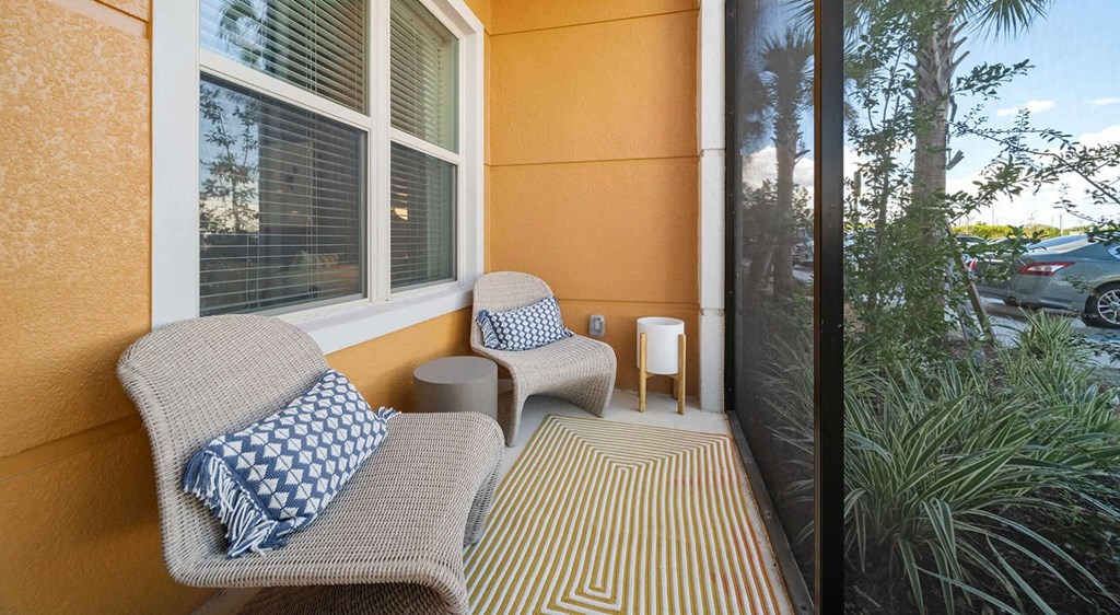 a porch with two chairs and a table and a window