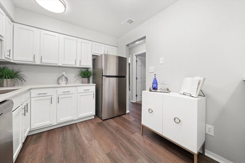 A kitchen with white cabinets and a stainless steel refrigerator.