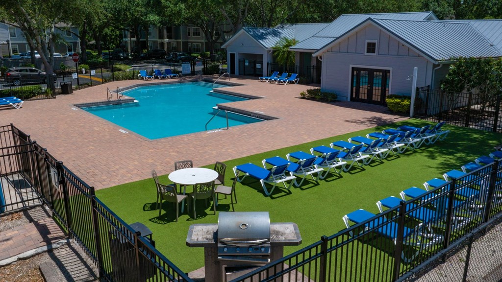 an aerial view of a swimming pool with tables and chairs