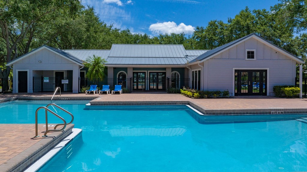 a swimming pool in front of a house with a pool