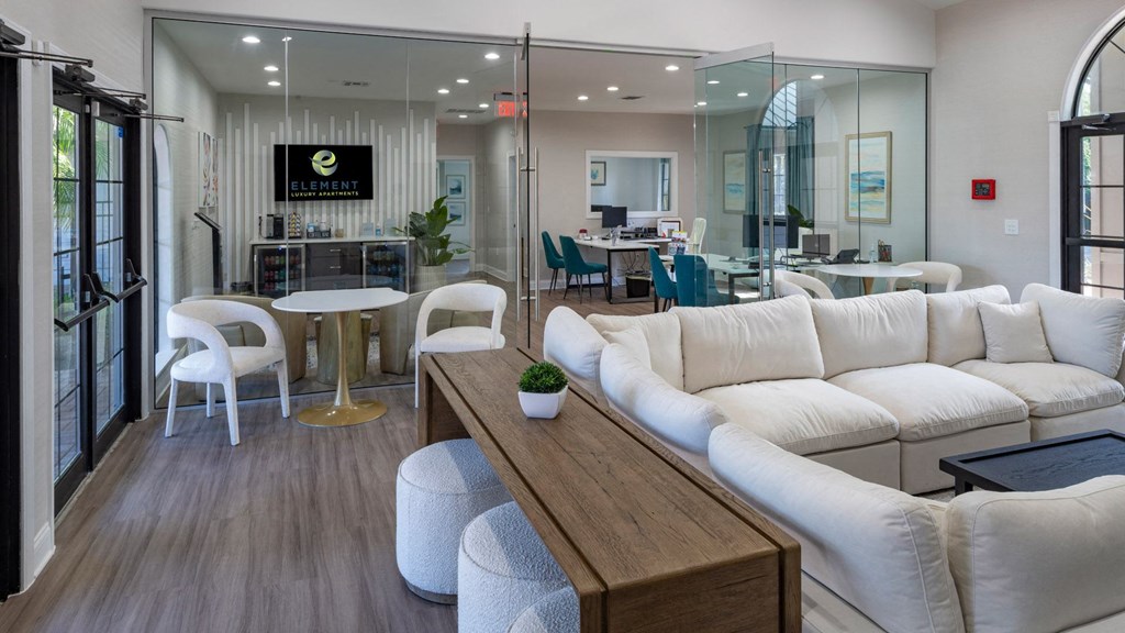 a living room with white couches and a wooden table
