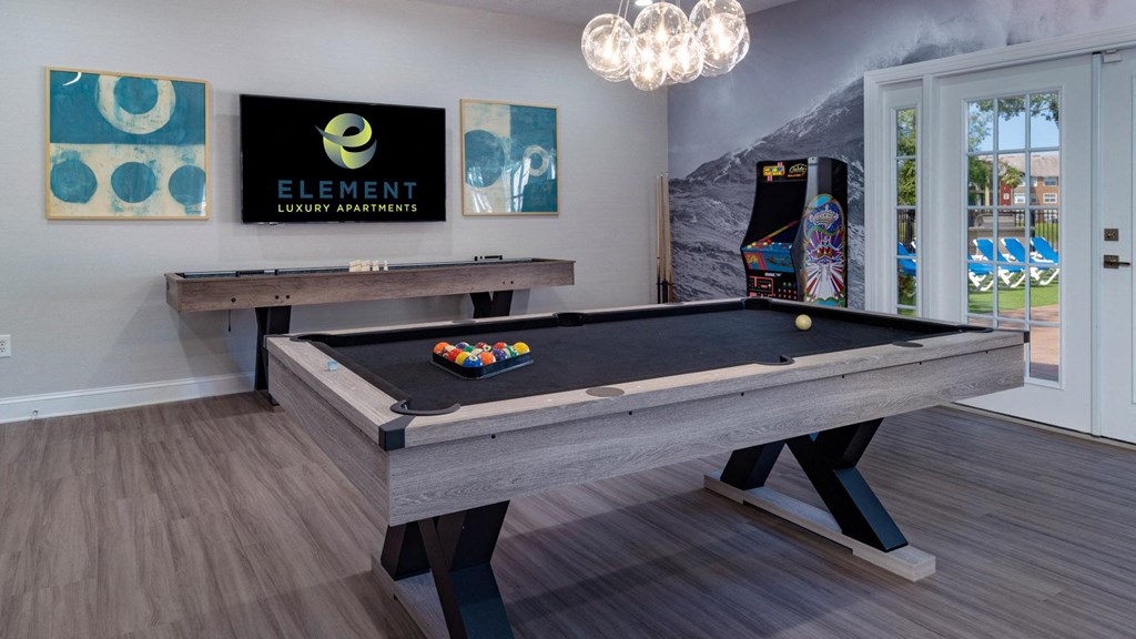 a billiards table in a game room with a pool table and other games