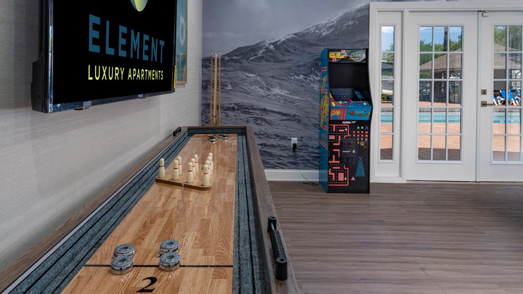 a bowling alley in a room with a board game and a large screen tv