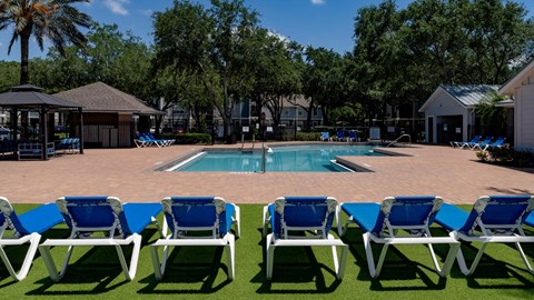 a pool with blue and white chairs around it