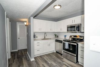 a kitchen with white cabinets and stainless steel appliances at Station JTown, Kentucky, 40299