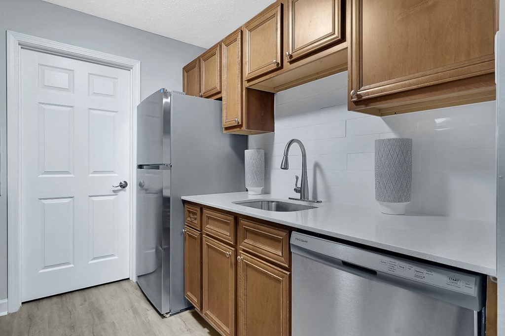 a kitchen with wooden cabinets and stainless steel appliances at Stonewater Apartments, Kentucky