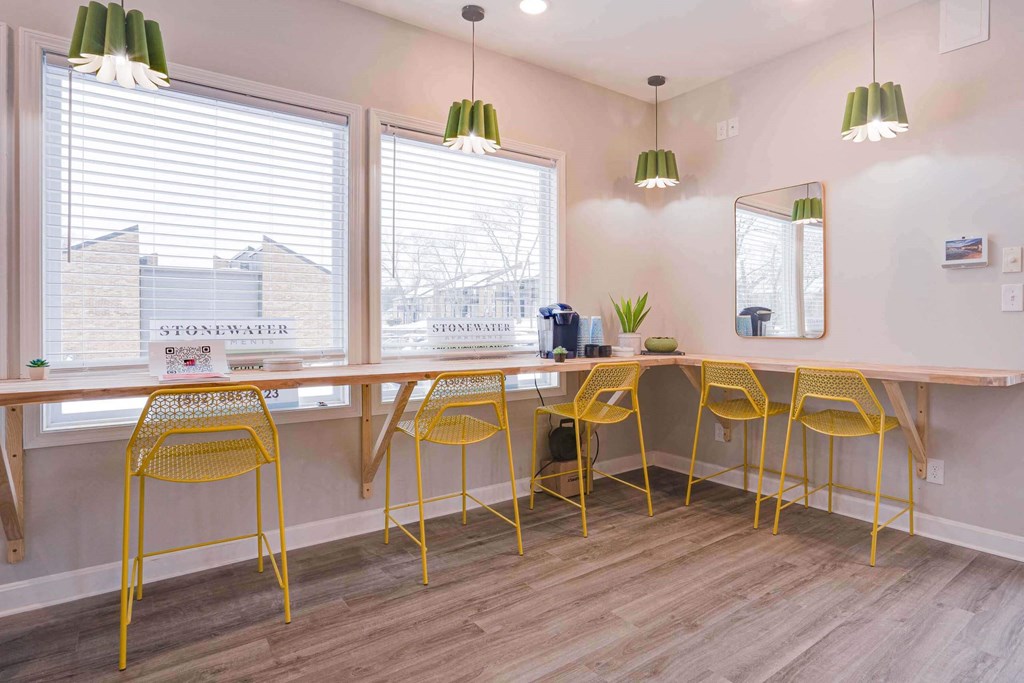 a long table with yellow chairs and a mirror on the wall at Stonewater Apartments, Louisville Kentucky