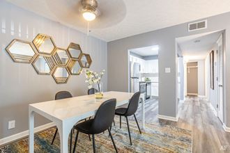 a dining room with a table and chairs and a kitchen in the background at Station JTown, Kentucky, 40299