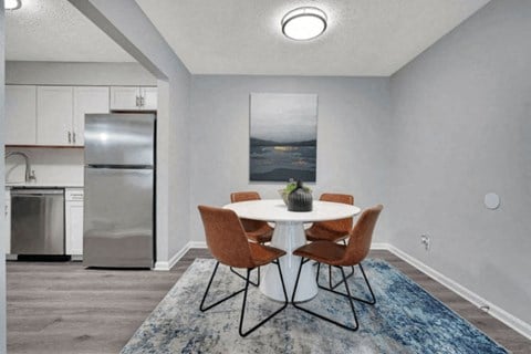 a dining room with a table and chairs and a refrigerator in the background at Enclave at Breckenridge Apartments, Louisville, 40220