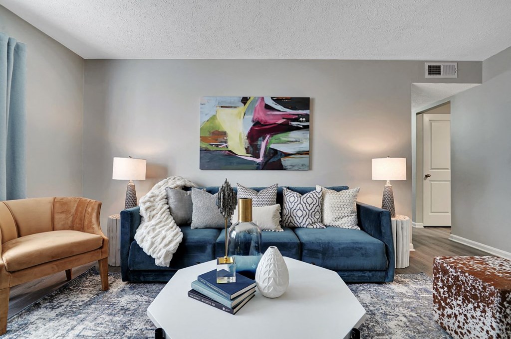 a living room with a blue couch and a white coffee table at Enclave at Breckenridge Apartments, Louisville, KY