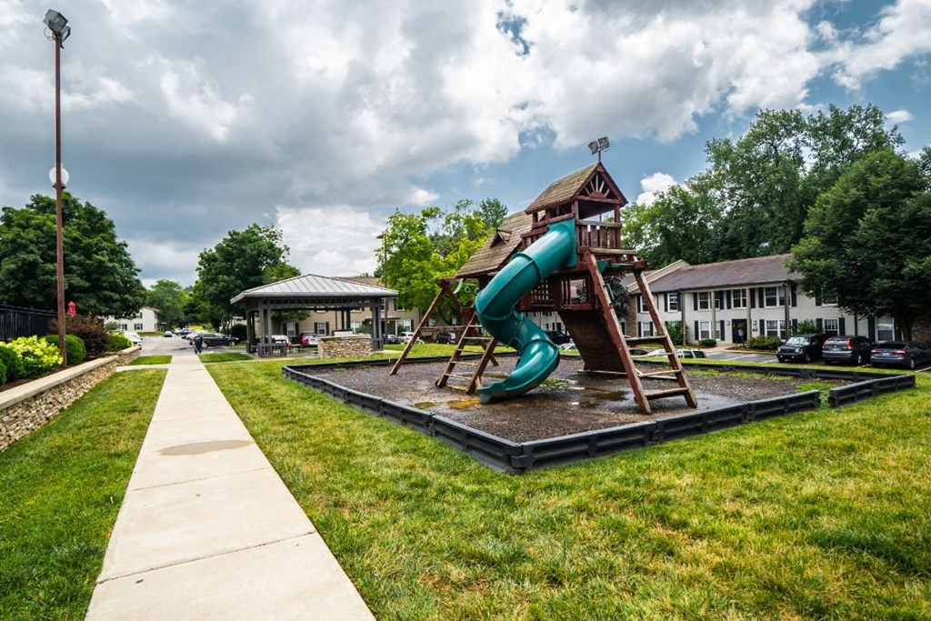 a playground with a slide and climbing structure in front of a building at Enclave at Breckenridge Apartments, Kentucky, 40220