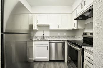 a kitchen with refrigerator and white cabinets at Southridge, Kansas City, Kansas