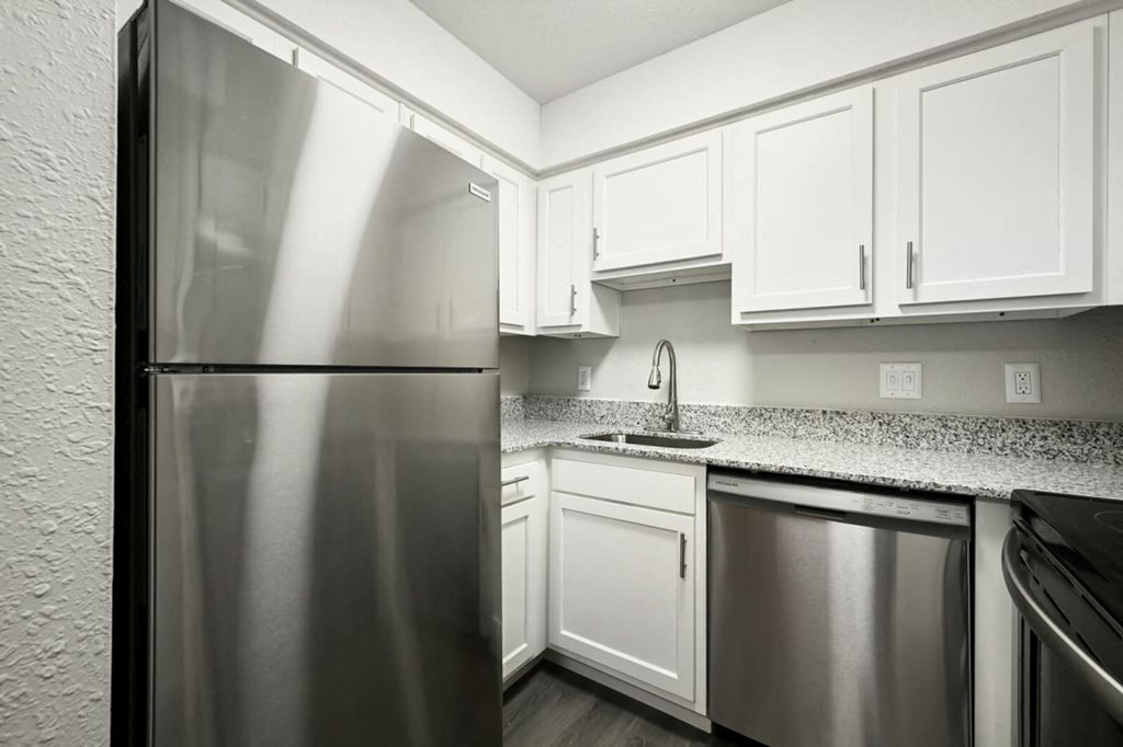 a kitchen with white cabinets and a stainless steel refrigerator at Southridge, Kansas City, KS, 66103