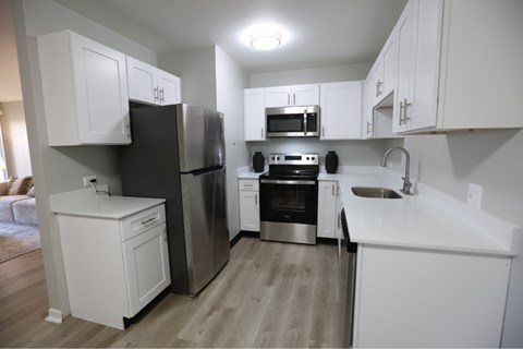 A kitchen with white cabinets and stainless steel appliances.