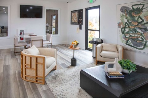 A living room with a black coffee table and a large painting on the wall.