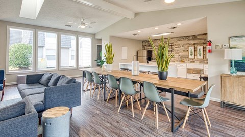 A modern dining room with a long table and chairs.