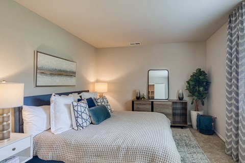 A bedroom with a large bed and a painting on the wall.