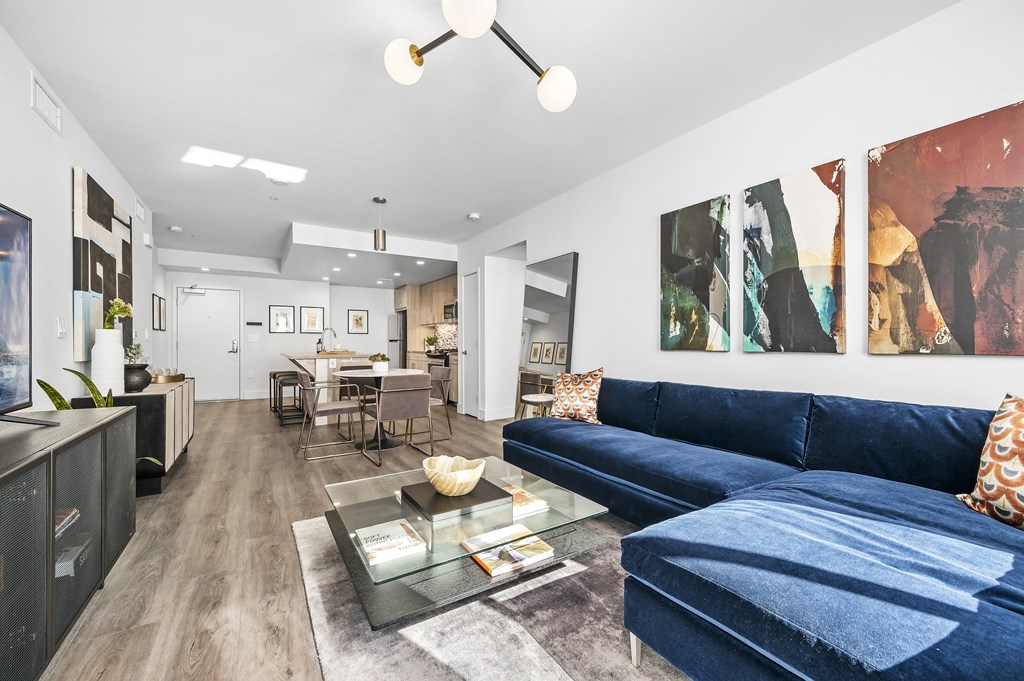 a living room with a blue couch and a glass coffee table