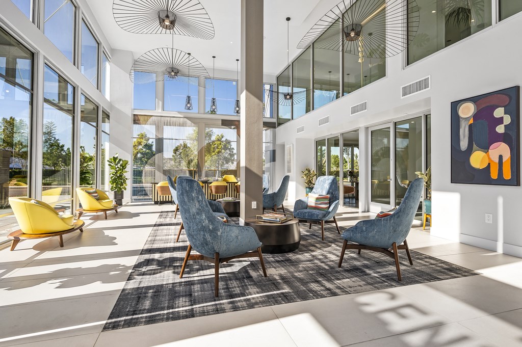 a lobby area with chairs and tables and large windows