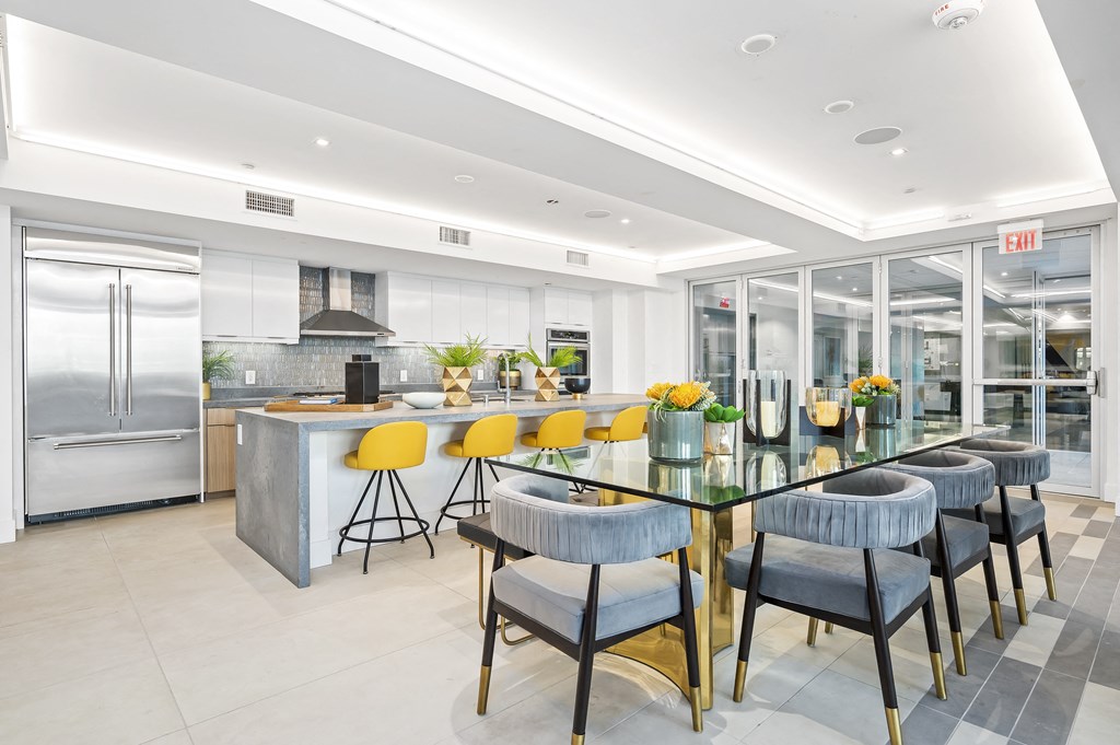 a large kitchen with a long table with yellow chairs