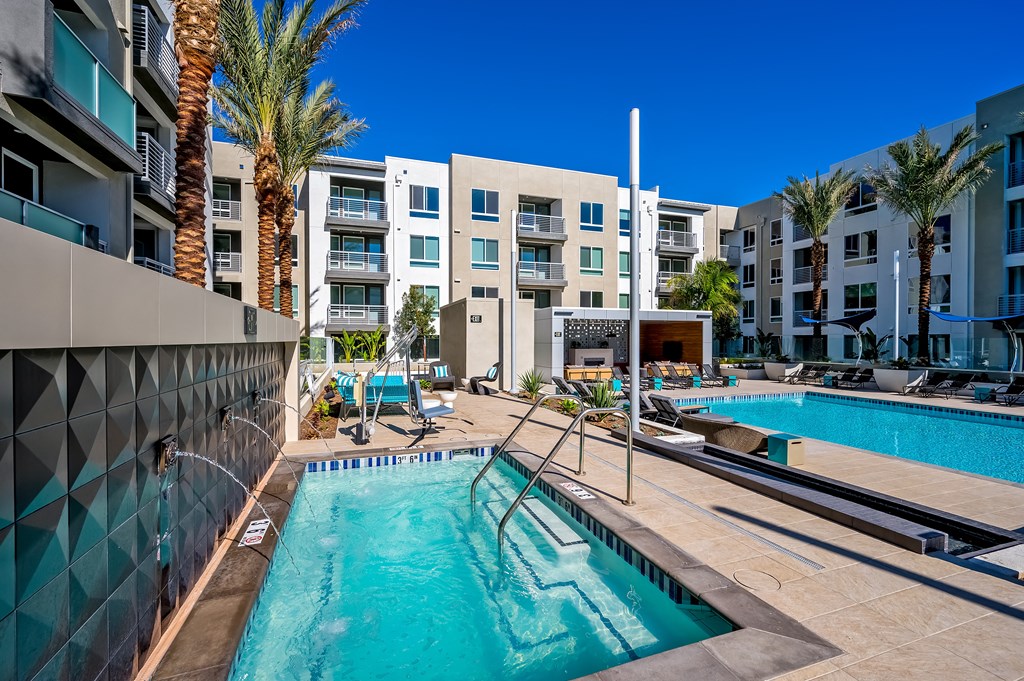 a swimming pool with an apartment building in the background
