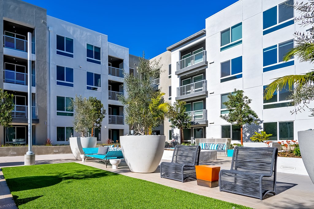 an apartment building with a lawn and chairs in front of it