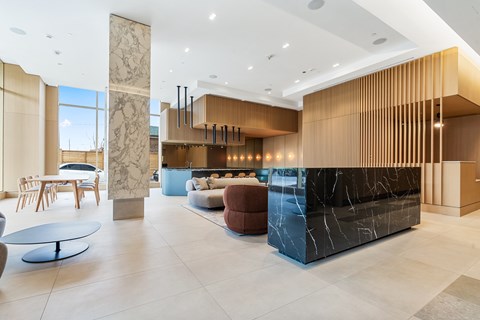 A reception area with a black marble counter and wooden paneling.