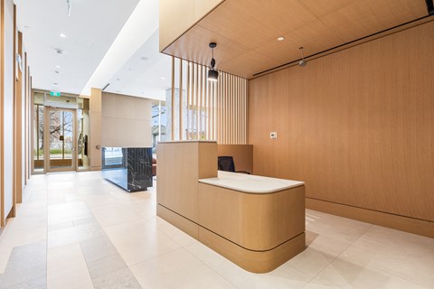 A reception area with a wooden counter and a marble floor.