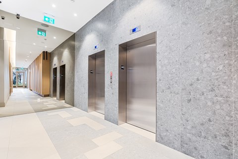 A long hallway with elevators on the right side.