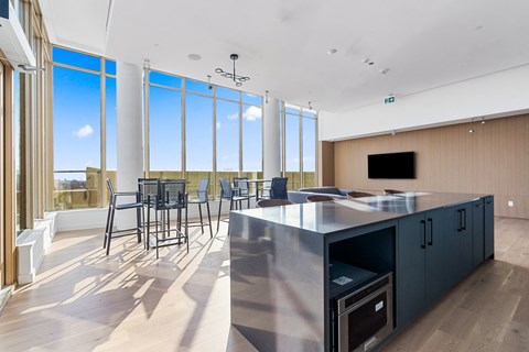 A modern kitchen with a large island and a view of the outdoors.