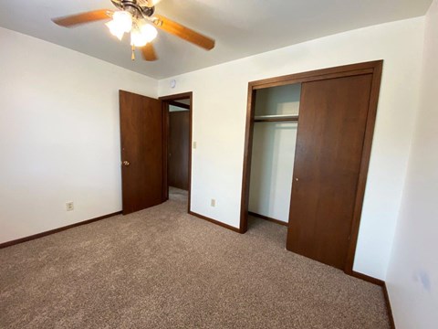 a bedroom with a closet and a ceiling fan