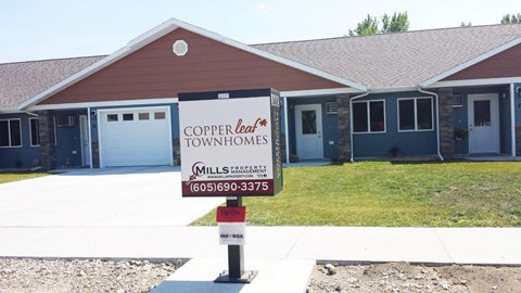 a house for sale with a sign in front of it