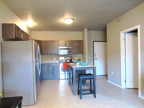 a kitchen with stainless steel appliances and a table with chairs