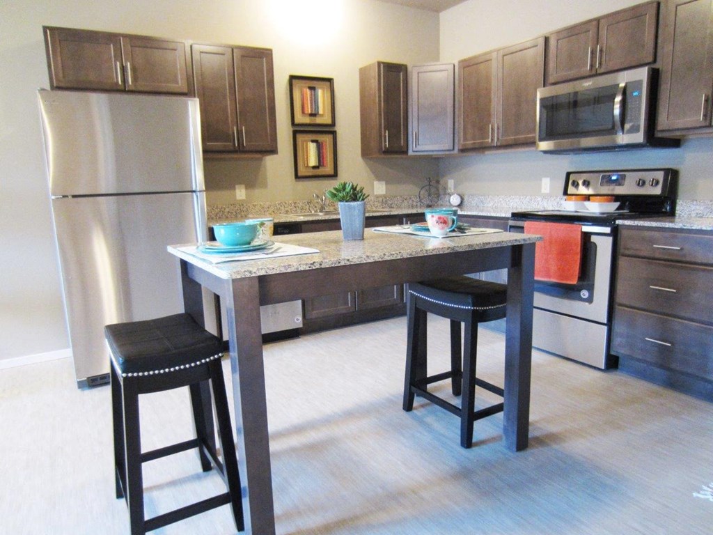 a kitchen with a center island and stainless steel appliances