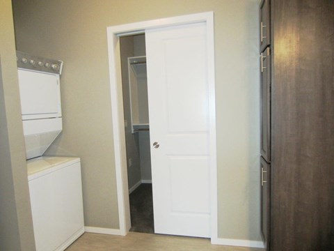 a closet with a white door and a washer and dryer