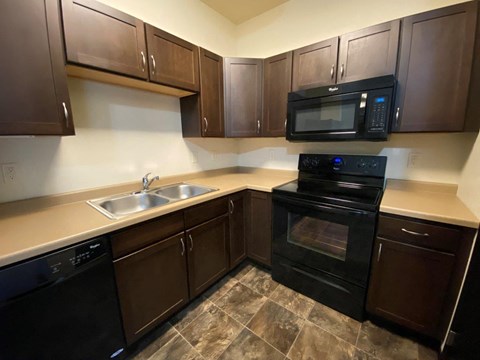a kitchen with black appliances and wooden cabinets