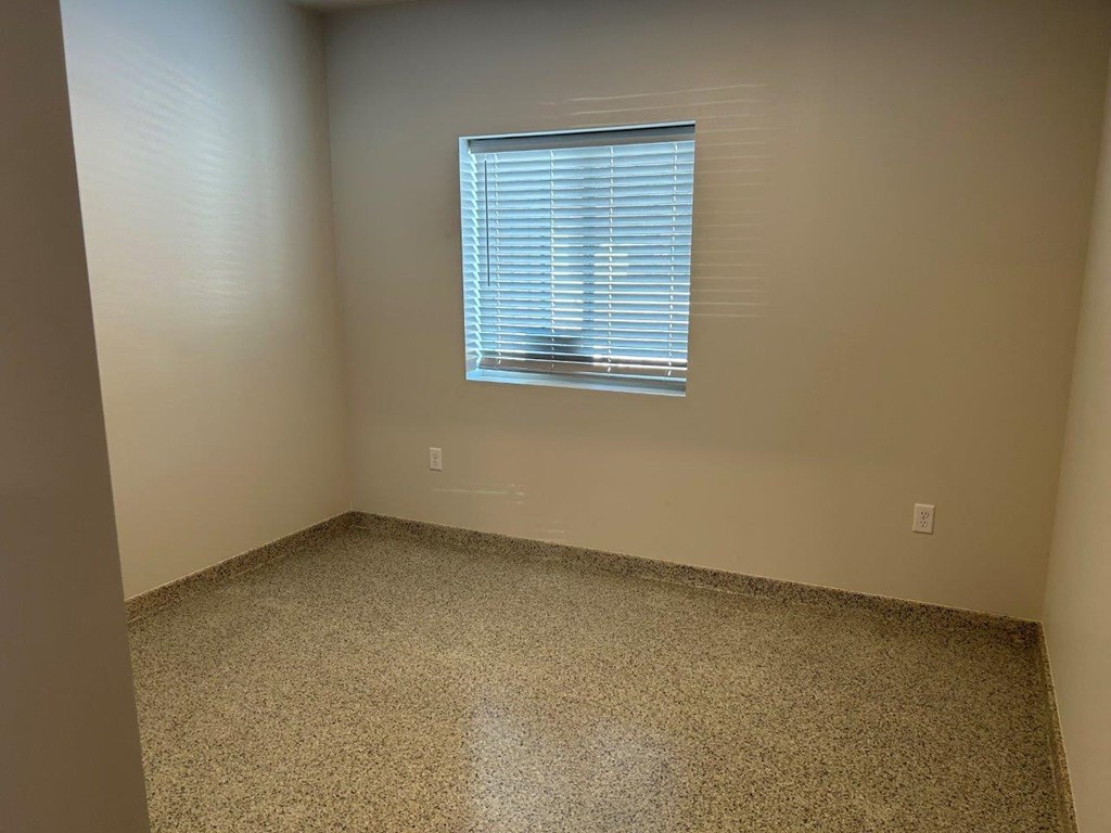 a room with a window and a carpeted floor