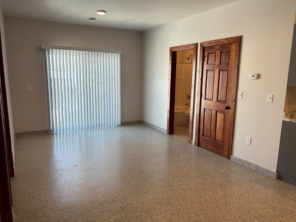 a living room with a window and a wooden door
